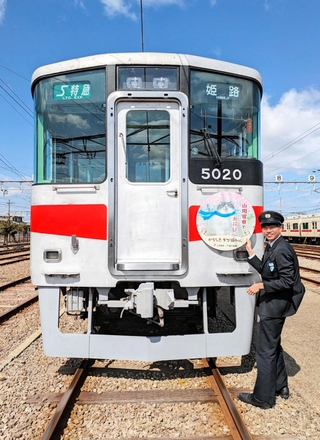 運行を始めた山陽電車のデブ猫電車。ヘッドマークを装着する職員＝明石市二見町