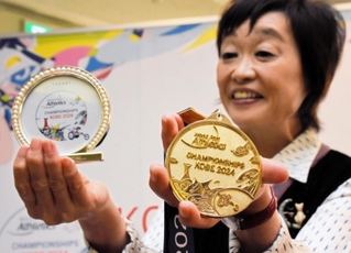 神戸ポートタワーなどがあしらわれたメダルと記念品のフォトフレームを手にする増田明美会長＝神戸市中央区加納町６、神戸市役所