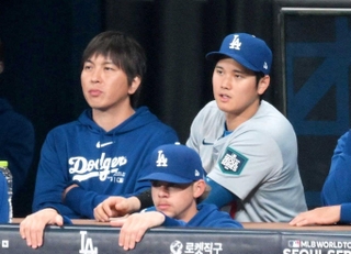 ベンチでパドレスの攻撃を見つめるドジャース・大谷翔平（中央右）と水原一平氏（同左）＝２０日、韓国・高尺スカイドーム
