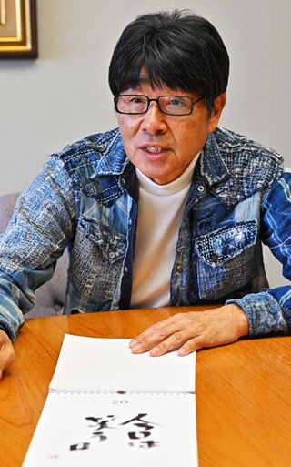 日めくりカレンダーにした作品「人生は笑う日」について語る原田伸郎さん＝神戸市中央区東川崎町１、ラジオ関西（撮影・斎藤雅志）