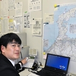 兵庫県警県民広報課で住民からの要望や苦情などに対応している葛西智広さん。壁には能登半島の地図が張り出されている＝神戸市中央区、県警本部