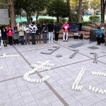 東日本大震災の発生時刻に合わせ、神戸で開かれた追悼行事。ろうそくで「３．11　ともに」の文字を書いた＝１１日午後２時４６分、神戸市中央区加納町６（撮影・小林良多）