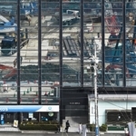街を行き交う人の頭上に映し出された再整備の工事現場＝神戸市中央区雲井通４