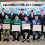蓮井賢一生活安全部長（後列中央）から感謝状を受け取った「功労店舗」のオーナーら（前列）＝兵庫県警本部