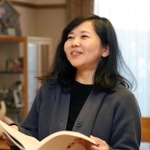 神戸レインボーハウスの冊子を手に、子どものころを思い出す中山舞さん＝神戸市東灘区本庄町１（撮影・長嶺麻子）