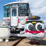 運行を始めた山陽電車のデブ猫電車。ヘッドマークを装着し、記念撮影するマルと山陽電車の公式キャラクター「ろっくん」＝明石市二見町