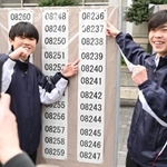 自身の受験番号を指でさし、記念撮影をする生徒たち＝１９日午前、神戸市長田区池田谷町２、長田高校（撮影・大田将之）