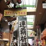 マジックナンバー「１４３」のボードの前で連覇を祈願する商店街関係者＝２７日午前、尼崎市神田中通３