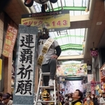 マジックナンバー「１４３」のボードの前で連覇を祈願する商店街関係者＝２７日午前、尼崎市神田中通３