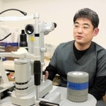 「後発白内障」の治療で用いるＹＡＧレーザーの照射器を扱う渡部暁也医師＝尼崎市潮江１、渡部眼科