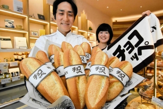 販売から５０周年を迎えたチョコッぺをアピールする壷井豪社長（左）と、オリジナルのタオルを広げる広報担当の千葉寛子さん＝神戸市中央区北長狭通１、ケルン三宮店