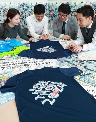 いよいよランナー募集が始まり、参加者対象に限定２千枚で販売される記念Ｔシャツやポスターなどの確認をする神戸マラソン実行委員会事務局の職員ら＝１２日、神戸市中央区北長狭通４