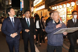 客引きの実態を説明する矢田貝充彦さん（右から２人目）と、視察する斎藤元彦知事（左）、石井登志郎市長（中央左）＝西宮市甲風園１