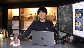 ＩＴエンジニア向けバー「ハックバー」を経営する井手翔陽さん。差し出すカクテルは自身お気に入りの「ＰＨＰ」＝神戸市中央区中山手通２