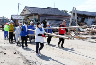「宝立七夕キリコまつり」で使うキリコを運ぶ兵庫県のボランティア＝１２日、石川県珠洲市宝立町鵜飼