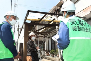 カーポートが破損した民家で被害状況を聞く気象庁機動調査班のメンバーら＝１７日午後０時３０分、姫路市広畑区長町２（撮影・辰巳直之）