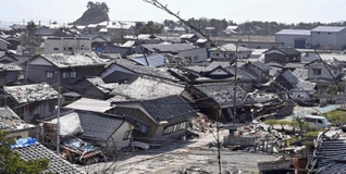 能登半島地震で被害の大きかった石川県珠洲市では、倒壊した民家がそのまま残っていた。奥には観光名所の見附島が見える＝３月３０日、石川県珠洲市宝立町（撮影・斎藤雅志）