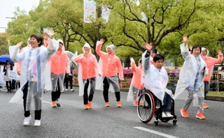 神戸まつりのおまつりパレードで沿道に向かって手を振る増田明美会長（右から２人目）と、選手やアンバサダー＝いずれも神戸市中央区加納町６