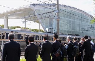 黙祷を捧げるために集まった人たちの前を電車が通過した＝２５日午前９時１６分、尼崎市久々知西町（撮影・笠原次郎）