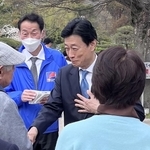 公園の来園者と握手する西村康稔氏＝６日午後、明石市の兵庫県立明石公園