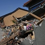 倒壊した民家が残ったままの能登半島地震の被災地。犠牲者が集中した地区では、花が供えられている家屋もあった＝３月３０日、石川県珠洲市宝立町（撮影・斎藤雅志）