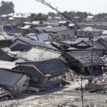 能登半島地震で被害の大きかった石川県珠洲市では、倒壊した民家がそのまま残っていた。奥には観光名所の見附島が見える＝３月３０日、石川県珠洲市宝立町（撮影・斎藤雅志）