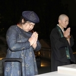 尼崎ＪＲ脱線事故の追悼行事で、写経を奉納し手を合わせる増田和代さん（左）と僧侶の露の団姫さん＝２４日夜、尼崎市久々知３（代表撮影）