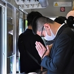尼崎ＪＲ脱線事故の発生現場付近を走行中の快速電車内で、犠牲者の冥福を祈る乗客ら＝２５日午前９時１５分、尼崎市内（撮影・斎藤雅志）