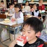 ストローなしで給食の牛乳を飲む児童＝明石市立朝霧小学校