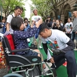 開幕２０日前イベントで金メダルレプリカを順番にリレーする参加者。右はやり投げ種目で出場する白砂匠庸さん＝２７日午後、神戸市中央区明石町（撮影・小林良多）