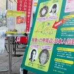 田中実さんら兵庫県内の拉致被害者や特定失踪者の写真を掲げて行われた署名活動＝２０２３年１２月、ＪＲ六甲道駅前