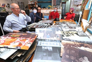 資料館で展示する写真パネルなどを前に、地域の歴史を振り返る金信鏞さん（左端）ら＝神戸市長田区若松町３