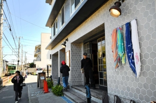 店舗入り口の脇にはブランドを代表するショールがなびく。店舗前には江ノ電が走り、観光客が絶え間なく通る＝神奈川県鎌倉市坂ノ下