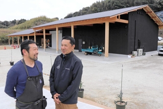 淡路島ワイナリーの前で今後の抱負を語る井壷幸徳さん（左）と小谷雄介さん＝淡路市仁井