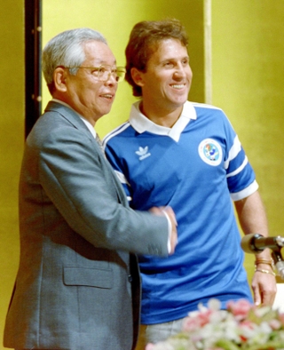 鹿島アントラーズの前身、住友金属入団が決まったジーコと握手する住友金属工業の新宮康男社長（左）＝１９９１年、東京都内