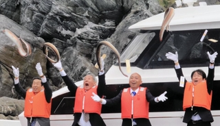 船上からハモを勢いよく海へ投げ入れる「鱧供養祭」の参列者ら＝15日午前、南あわじ市沼島