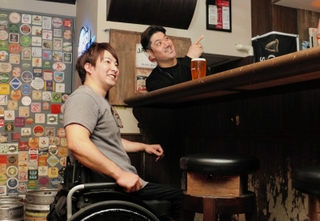 行きつけのアイリッシュパブで店主の阪上仁哉さん（右）と談笑する光瀬智洋さん＝神戸市中央区中山手通１、ザ　レッド　ディア