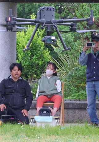 足でドローンを操縦して飛行させる宮崎美侑さん＝１９日午後、神戸市須磨区緑台、神戸総合運動公園コスモスの丘（撮影・笠原次郎）