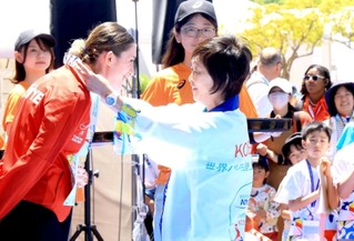 メダル授与式で選手にメダルをかける増田明美会長と見守る人たち＝１８日、ユニバー記念競技場（撮影・笠原次郎）