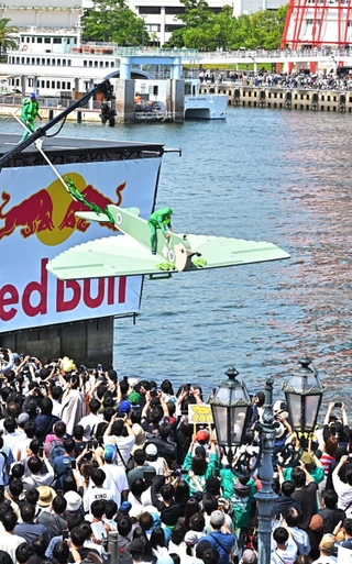 滑走路から手作りの人力飛行機で飛び出す参加者ら＝２６日午後、神戸市中央区東川崎町１（撮影・斎藤雅志）