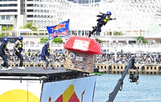 滑走路から手作りの人力飛行機で飛び出す参加者ら＝２６日午後、神戸市中央区東川崎町１（撮影・斎藤雅志）