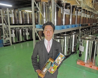 「古酒の文化を復活させたい」と意気込む匠創生の安村亮彦代表。後ろは古酒を貯蔵、熟成させているステンレス製容器＝加古川市野口町良野