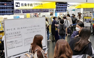 滑走路閉鎖のため、払い戻しなどの手続きのためにチェックインカウンターに列を作る乗客＝３１日午後３時３２分、神戸市中央区、神戸空港