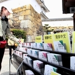 外国語のパンフレットを手にする訪日客。この配布数を基に外国人入城者数を集計する＝姫路市本町