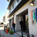 店舗入り口の脇にはブランドを代表するショールがなびく。店舗前には江ノ電が走り、観光客が絶え間なく通る＝神奈川県鎌倉市坂ノ下