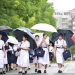 雨の中、真っ白な夏服で通学する生徒たち＝１３日午前、神戸市灘区（撮影・大田将之）