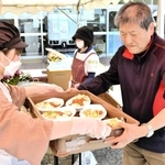 炊き出しのカレーライスを「神戸・心絆」のメンバー（左）から受け取る避難者