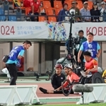 競技用車いす（レーサー）が接触して複数人の選手が転倒し、選手の状態を確認するメディカルスタッフら＝１８日午後、ユニバー記念競技場（撮影・小林良多） 