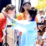 メダル授与式で選手にメダルをかける増田明美会長と見守る人たち＝１８日、ユニバー記念競技場（撮影・笠原次郎）