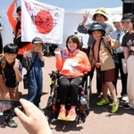 女子円盤投げ（座位Ｆ５３）銀メダリストの鬼谷慶子選手と記念写真に納まる子どもら＝いずれも神戸市須磨区緑台